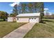 A large shed with a concrete driveway and surrounding green grass at 300 Smith Ave, Bowdon, GA 30108