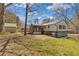 View of the house with a metal roof, screened porch, detached garage and a grassy backyard at 6414 Bimini Dr, Forest Park, GA 30297