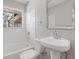 Well lit bathroom featuring a tub, shower and modern pedestal sink at 6414 Bimini Dr, Forest Park, GA 30297