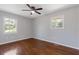 A bright bedroom featuring hardwood floors, fan and two windows at 6414 Bimini Dr, Forest Park, GA 30297