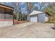 Long driveway leading to detached garage with mature landscaping and covered porch at 6414 Bimini Dr, Forest Park, GA 30297