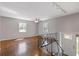 Bright living room featuring hardwood floors, large windows, and access to the staircase and front entrance at 6414 Bimini Dr, Forest Park, GA 30297