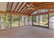 Inviting screened porch featuring a vaulted ceiling, ceiling fan, and view of wooded backyard at 6414 Bimini Dr, Forest Park, GA 30297