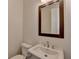 Elegant half-bathroom with a white sink and a dark wood-framed mirror at 717 Farmstead Rd, Suwanee, GA 30024