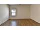 Spacious bedroom featuring wood-look floors and a bright window at 717 Farmstead Rd, Suwanee, GA 30024