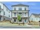 Charming three-story home with a welcoming front porch and beautifully landscaped front yard at 717 Farmstead Rd, Suwanee, GA 30024
