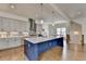 Open concept kitchen with island, gray and dark blue cabinets, quartz countertops and stainless steel appliances at 717 Farmstead Rd, Suwanee, GA 30024