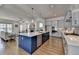 Open-concept kitchen with a large island, stainless steel appliances, and seamless flow into the living area at 717 Farmstead Rd, Suwanee, GA 30024