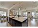 Open concept kitchen with large island, quartz countertops, stainless steel sink, dark cabinets and hardwood floors at 717 Farmstead Rd, Suwanee, GA 30024