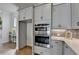 Gourmet kitchen featuring stainless steel appliances, a built in oven and microwave, and gray cabinets at 717 Farmstead Rd, Suwanee, GA 30024