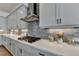 Modern kitchen featuring gray cabinets, stainless steel range hood, gray subway tile backsplash and quartz countertops at 717 Farmstead Rd, Suwanee, GA 30024