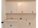 Laundry room featuring cabinets with hardware, a countertop, and a sink at 717 Farmstead Rd, Suwanee, GA 30024