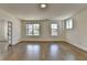Spacious living room with hardwood floors, neutral walls and multiple windows for plenty of natural light at 717 Farmstead Rd, Suwanee, GA 30024