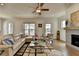 Cozy living room with a leather sectional, fireplace, ceiling fan, natural light and hardwood floors at 717 Farmstead Rd, Suwanee, GA 30024