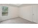 Bright bedroom with neutral walls, plush carpet, a window, and a closet door at 164 Edison Dr, Stockbridge, GA 30281