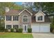 Charming two-story home featuring a stone facade, a two-car garage, and manicured front lawn at 164 Edison Dr, Stockbridge, GA 30281