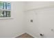 Clean laundry room featuring a window, white walls, wire shelving, and electrical and plumbing hookups at 164 Edison Dr, Stockbridge, GA 30281