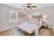 Bright bedroom with neutral tones, featuring a plush bed, bench, ceiling fan, and two windows at 2243 Newnan St, Atlanta, GA 30344
