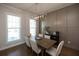 Bright dining area features wainscoting, modern light fixture, hardwood floors, and natural light from large windows at 532 Pearl St, Cumming, GA 30040