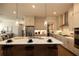 Bright kitchen features stainless appliances, stone countertops, pendant lighting, and bar stool seating at the island at 532 Pearl St, Cumming, GA 30040