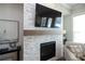 Cozy living room featuring a stone fireplace with wooden mantle and a mounted television for modern comfort at 532 Pearl St, Cumming, GA 30040