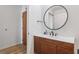 Modern bathroom with wood vanity, white countertop, and round mirror at 860 Peachtree Ne St # 2212, Atlanta, GA 30308