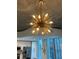 Modern chandelier illuminating a living space with stainless steel appliances and expansive city views at 860 Peachtree Ne St # 2212, Atlanta, GA 30308