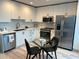 Modern kitchen features white cabinets, stainless steel appliances, quartz countertops, and adjacent dining area at 860 Peachtree Ne St # 2212, Atlanta, GA 30308