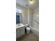 Bright bathroom with a shower-tub combo, white vanity, and a decorative light fixture at 10918 Gallier St, Alpharetta, GA 30022