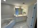 Spacious bathroom with dual sinks, vanity, tub, and tile flooring at 10918 Gallier St, Alpharetta, GA 30022