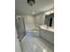 Bathroom featuring a glass-enclosed shower, bathtub, double vanity, and tile flooring at 10918 Gallier St, Alpharetta, GA 30022