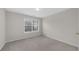 Bright bedroom featuring neutral walls, carpet, and a window providing natural light at 5280 Oak Hill Ter, Cumming, GA 30040