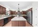 Modern kitchen with stainless steel appliances, brown cabinetry, and island at 5280 Oak Hill Ter, Cumming, GA 30040