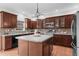 Kitchen with stainless steel appliances, brown cabinetry, and a central island at 5280 Oak Hill Ter, Cumming, GA 30040
