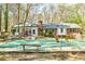 Backyard featuring a covered pool, a brick and white house, mature trees, and a wooden bench for relaxing at 730 Ponderosa Ct, Fayetteville, GA 30214