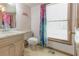 Cozy bathroom with a floral shower curtain, window, vanity with white countertop and toilet at 730 Ponderosa Ct, Fayetteville, GA 30214