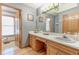 Well-lit bathroom features wood cabinets, a white countertop, and a large mirror at 730 Ponderosa Ct, Fayetteville, GA 30214