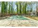 View of a covered pool in a wooded backyard with deck extending into the yard at 730 Ponderosa Ct, Fayetteville, GA 30214