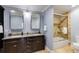Bathroom featuring double sink vanity, granite countertops, and a shower-tub combination with glass doors at 105 Jefferson Cir, Sandy Springs, GA 30328