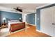 Spacious bedroom features blue accent wall, hardwood floors, ceiling fan, and a doorway to another room at 105 Jefferson Cir, Sandy Springs, GA 30328