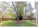 Picturesque backyard featuring mature trees, a wooden fence, and manicured lawn at 1855 Keswick Place Dr, Lawrenceville, GA 30043