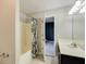 Bathroom features shower and tub combination, sink with dark cabinets, and bright lighting at 1855 Keswick Place Dr, Lawrenceville, GA 30043