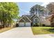 Charming two-story home with a two-car garage, manicured lawn, and mature trees at 1855 Keswick Place Dr, Lawrenceville, GA 30043