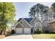 Charming two-story home with a two-car garage, manicured lawn, and mature trees at 1855 Keswick Place Dr, Lawrenceville, GA 30043
