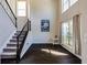 Light-filled foyer featuring dark wood floors, staircase with iron railings, and tall windows at 1855 Keswick Place Dr, Lawrenceville, GA 30043