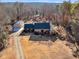 An aerial view showcases the brick home, detached garage, and surrounding wooded landscape at 35 Tracechain, Stockbridge, GA 30281