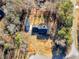 Aerial view of the home, garage, and driveway shows the surrounding wooded landscape at 35 Tracechain, Stockbridge, GA 30281