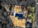 An aerial view shows the home, detached garage, driveway, and surrounding treed lot at 35 Tracechain, Stockbridge, GA 30281
