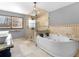 Luxurious bathroom featuring a large soaking tub and walk-in shower with stone tile at 35 Tracechain, Stockbridge, GA 30281