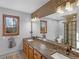 Bathroom features double sinks with granite countertop, natural wood cabinets, and black framed shower at 35 Tracechain, Stockbridge, GA 30281